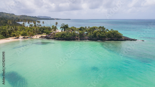 Top view of beautiful white sand beach with turquoise sea water and palm trees, aerial drone shot. Nature background