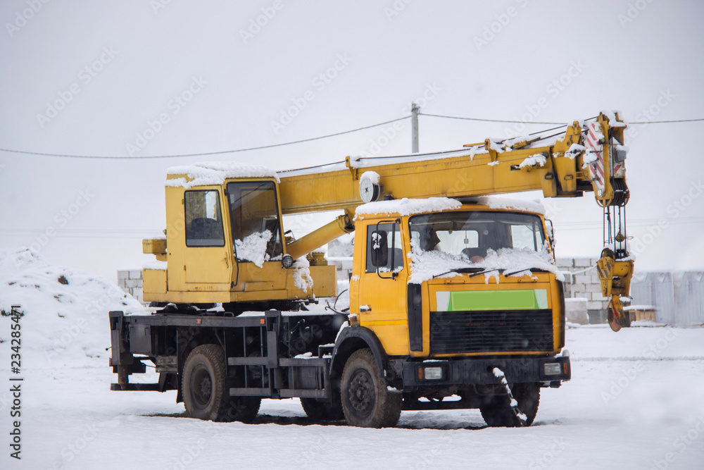 Frozen mobile construction crane in the city street in winter