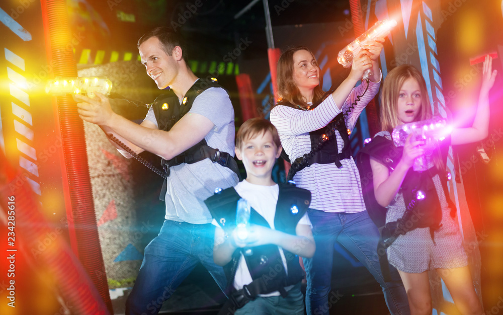 Obraz premium Kids and parents in beams during laser tag game