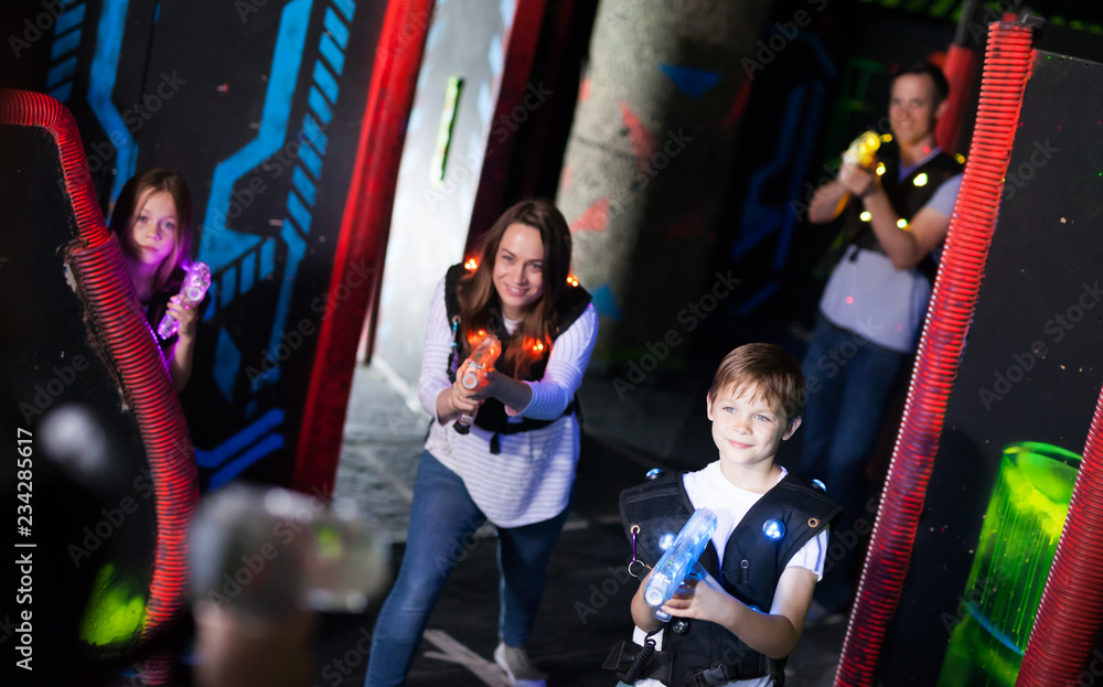 Fototapeta premium Parents and children playing laser tag