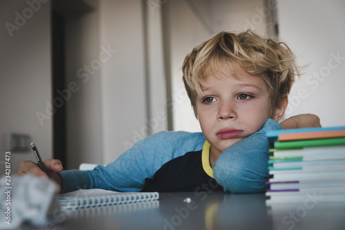 little boy tired stressed of reading, doing homework