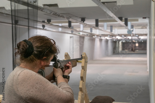 Wallpaper Mural Frau mit Dutt zielt auf auf einer Schießanlage mit einem Gewehr  Torontodigital.ca