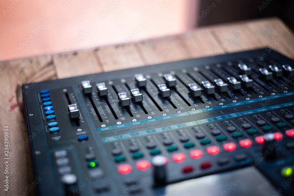 The DJ is adjusting the volume of the sound. Professional audio mixing console The DJ is adjusting the volume of the sound. Professional audio mixing console
