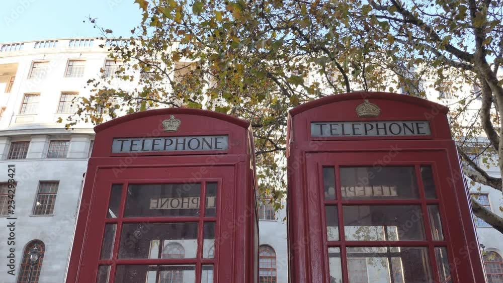 Two red telephone booths in the street in autumn. London. Two red telephone booths in the street in autumn. London.