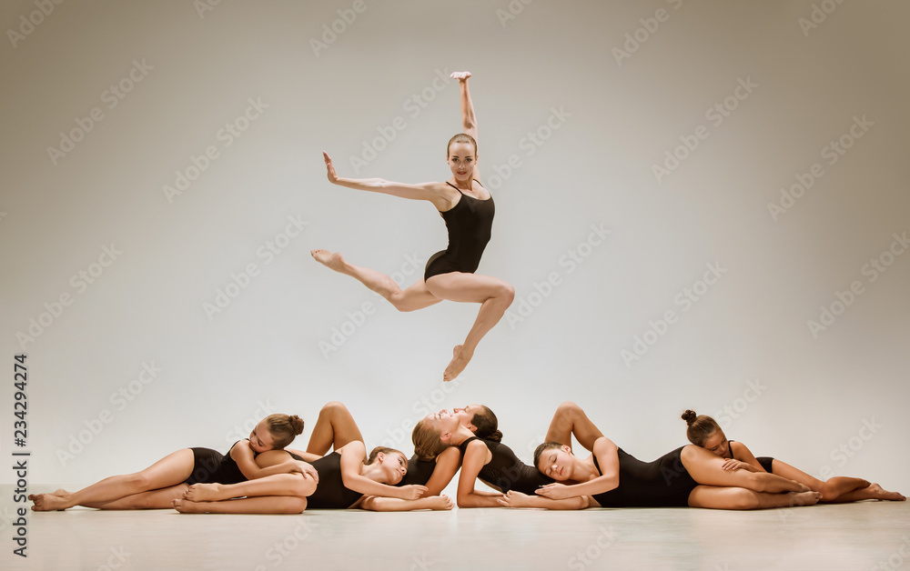 Fototapeta premium The group of modern ballet dancers dancing on gray studio background