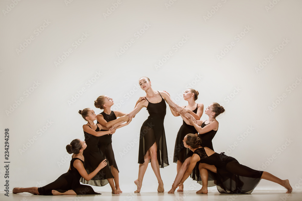 Naklejka premium The group of modern ballet dancers dancing on gray studio background