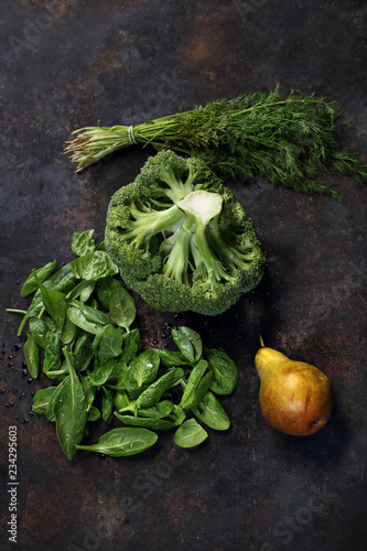 Zielone warzywa, zdrowa dieta . Brokułodego szpinaku, pęczek koperku i gruszka na ciemnym tle.