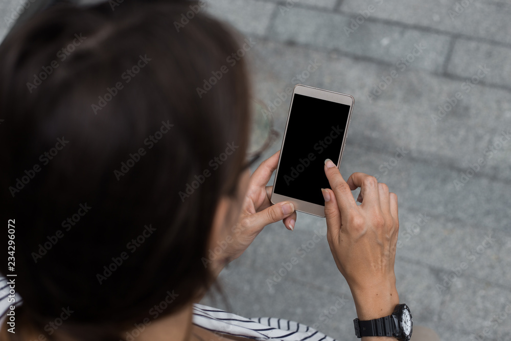 Cropped shot view of womans hands holding smart phone with blank copy space screen for your information content about app, logo or copy, using free wifi or 4G Internet abroud. App for taxi servises