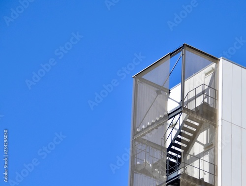 Geometric building and steal stair with rich blue sky © Surakit