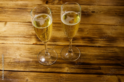 Two glasses of champagne on wooden table