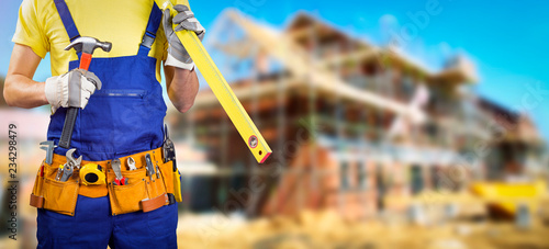 worker with tool belt in house construction site
