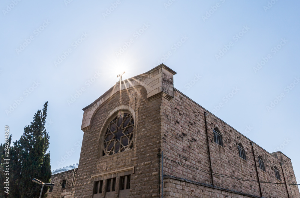 The sun illuminates the holy cross at a Christian monastery located on Derekh Shechem street - Nablus Road -  in Jerusalem, Israel