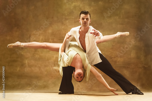 Flexible young modern couple dancing tango in studio. Fashion portrait of attractive dancing couple. Man and woman. Passion. Love. perfect skin facial and make-up. Human emotions - love and passion