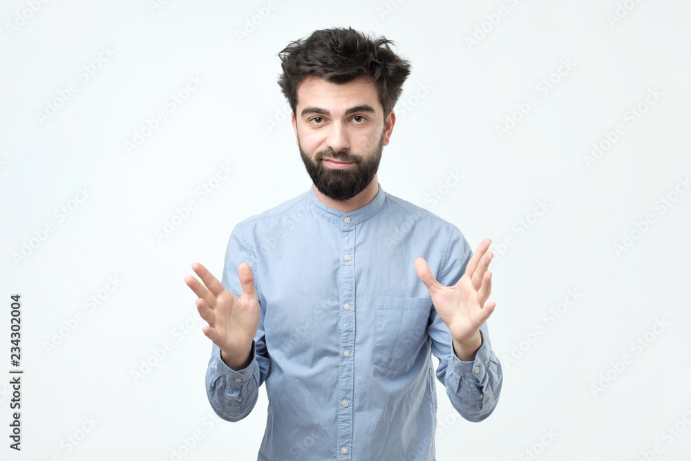 Handsome young man explaining something and gesturing with his hands Handsome young man explaining something and gesturing with his hands