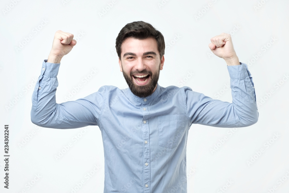 Portrait of happy spanish man with fists up celebrating his victory Portrait of happy spanish man with fists up celebrating his victory
