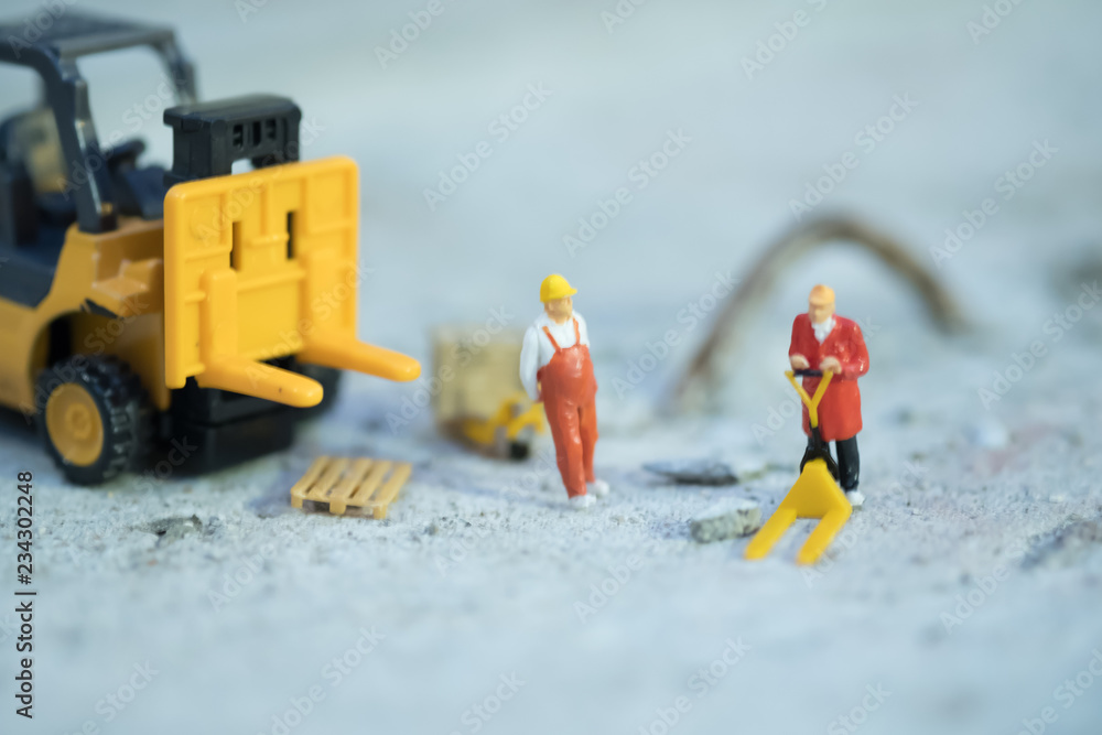 Naklejka premium Miniature warehouse workers forklift carrying goods box