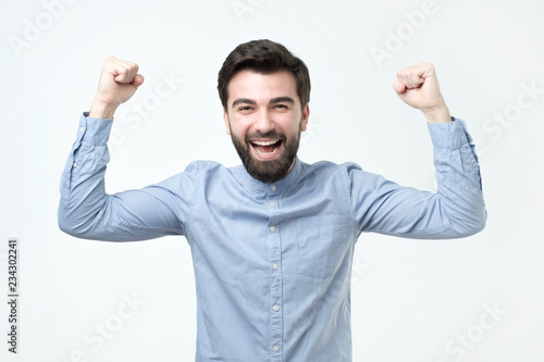 Portrait of happy spanish man with fists up celebrating his victory