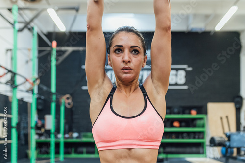young woman training indoor crossfit gym - sportive, training, healthy lifestyle concept
