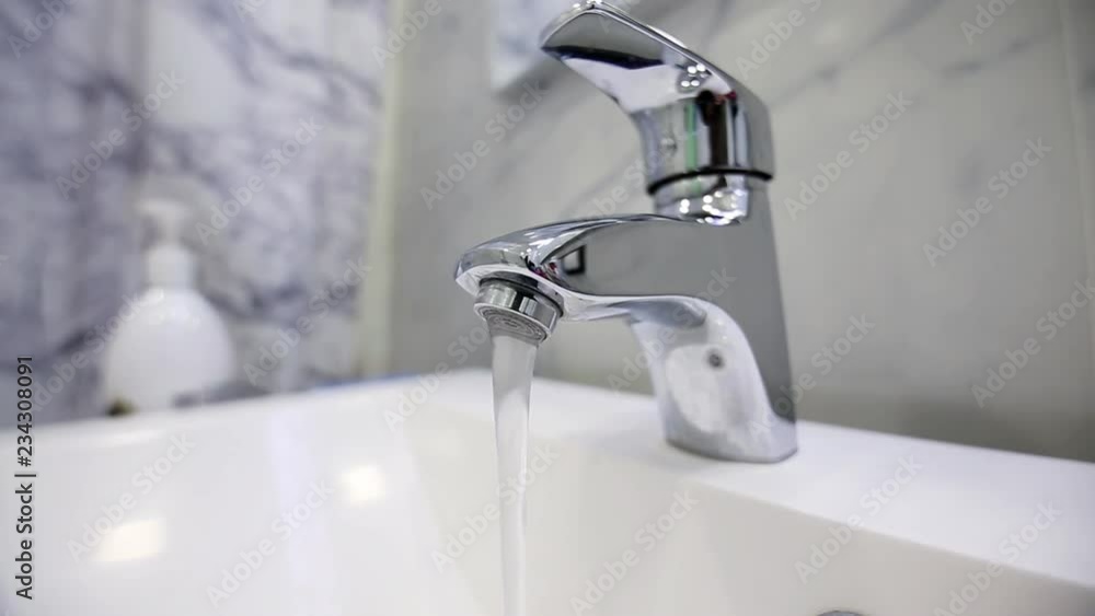 flowing from the modern tap water in the bathroom. saving of natural resources. flowing from the modern tap water in the bathroom. saving of natural resources.