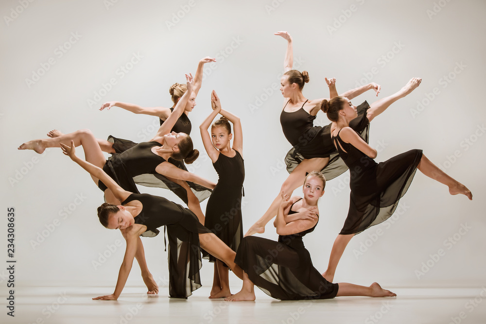 Fototapeta premium The group of modern ballet dancers dancing on gray studio background