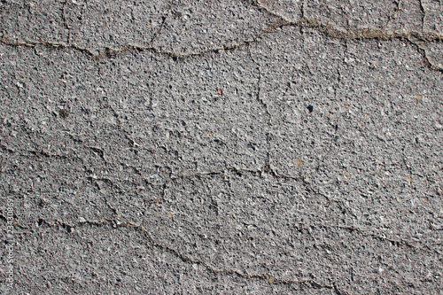 Old asphalt surface texture detail with cracks fractures lines close up