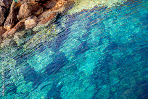 Blue clear water and rocks of island Santorini, Greece
