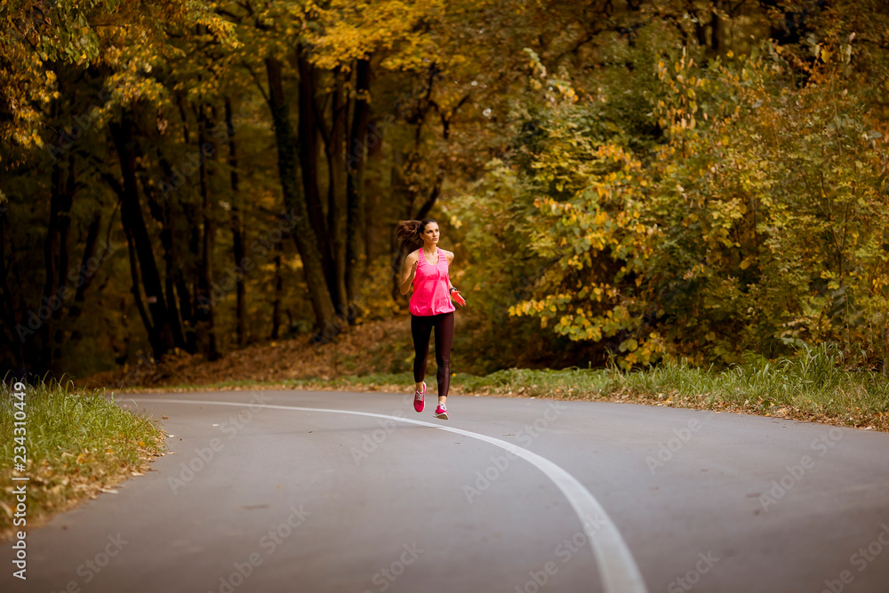Young fitness woman running at forest trail Young fitness woman running at forest trail