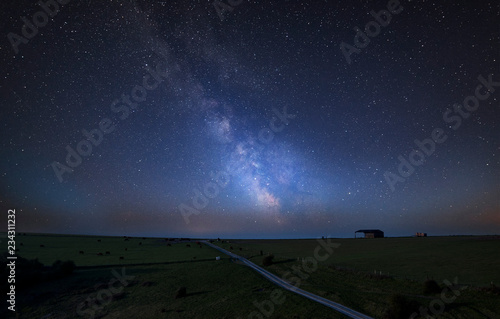 Vibrant Milky Way composite image over landscape of English countryside