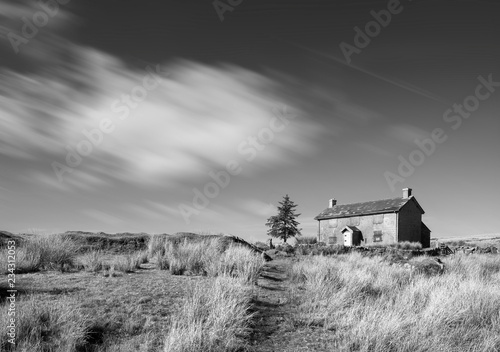 Stunning toned black and white landscape image of Nun's Cross Farm in Dartmoor