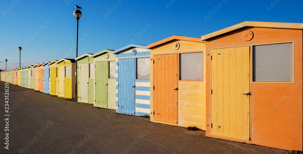 Naklejka premium A row of twenty colorful beach huts with a diminishing perspective on a promenade, Seaford, Sussex, UK