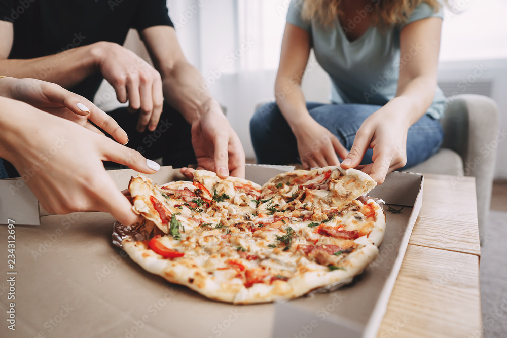 friendship, conversation, food delivery, togetherness, leisure, party. young cheerful people talking and having fun together in living room, students chatting sharing pizza at table, close up