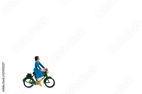 Clipping path, selective focus miniature woman in blue dress ride a classic bicycle and looking to something isolated with copy space.