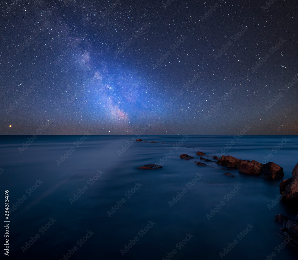 Fototapeta premium Vibrant Milky Way composite image over landscape of Beautfiul long exposure of sea over rocks