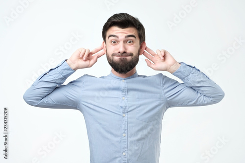 Hispanic man with funny monkey face over gray background