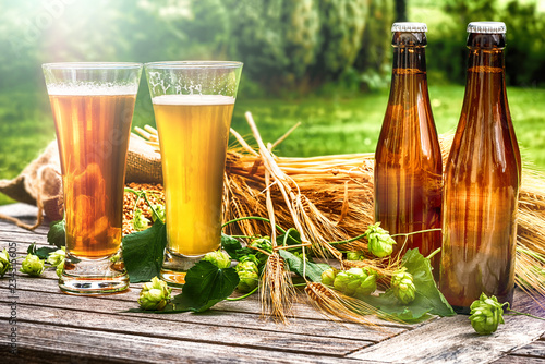 Glasses with fresh cold beer in rustic setting photo