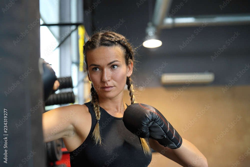 Obraz premium Woman training whilst boxing a punching bag