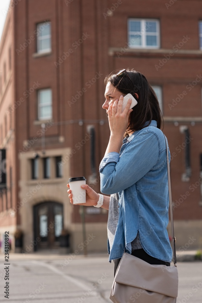 Woman having coffee while talking on mobile phone Woman having coffee while talking on mobile phone