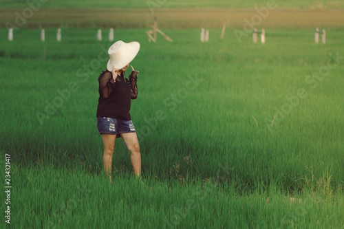 Woman takes a photo by smartphone in the rice fields