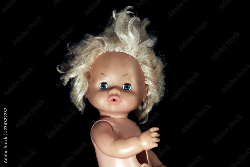 Fototapeta premium Plastic doll on a black background.
