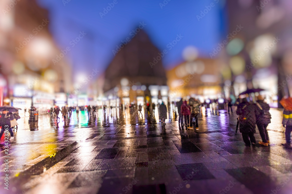 crowd of people walking on the night rainy streets in the city 
