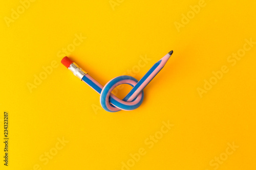 Flexible pencil on a yellow background. Bent pencils two-color. Business concept