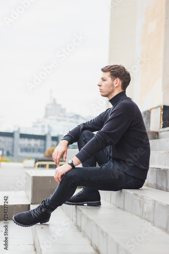 The young guy is sitting on the steps