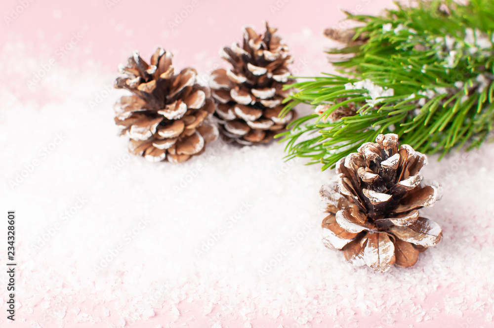 Christmas background, green pine branches, cones decorated with snow on snowy pink background. Creative composition with border and copy space design. New Year's, holiday, christmas, decoration