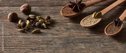 Cardamom, cloves, nutmeg, star anise, allspice. Different types of whole Indian spices in wooden background close-up. Healthy food.