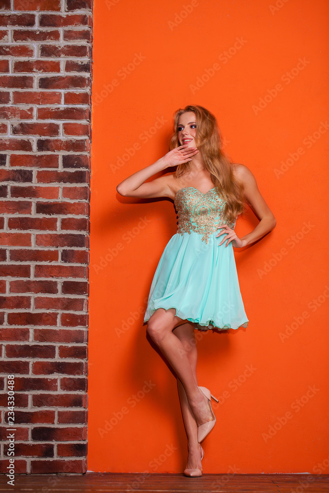 Full body portrait of a beautiful young blonde woman in a turquoise dress Full body portrait of a beautiful young blonde woman in a turquoise dress
