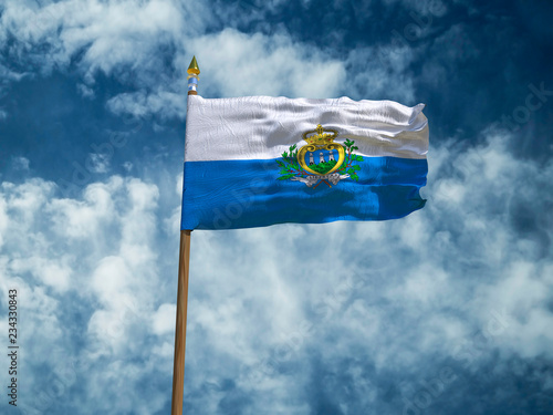 San Marino flag Silk waving flag of San Marino made transparent fabric with wooden flagpole gold spear on background sunny blue sky white smoke clouds real retro photo Countries world 3d illustration