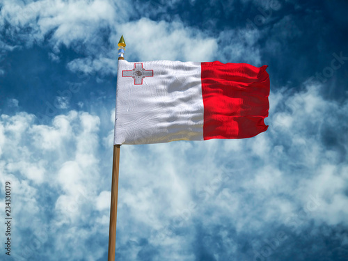 Malta flag Silk waving flag of Malta made transparent fabric with wooden flagpole gold spear on background sunny blue sky white smoke clouds real retro photo Countries of world 3d illustration