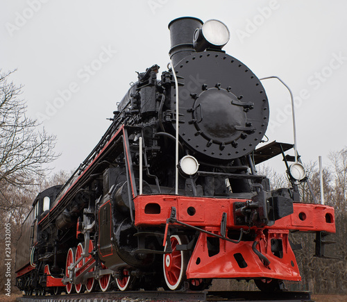 Old black steam locomotive with red decoration, front view