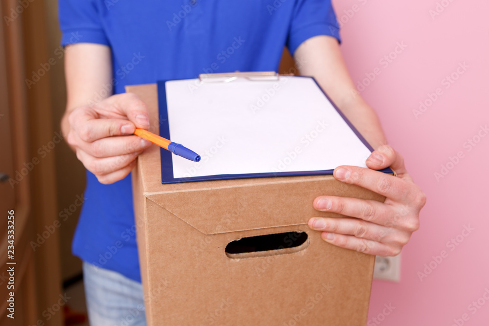 Photo close up of courier with pen, blank sheet of paper, cardboard box Photo close up of courier with pen, blank sheet of paper, cardboard box