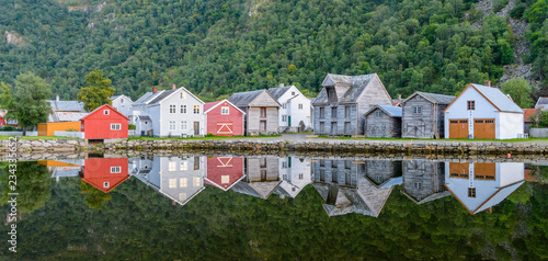 The old town of Gamla Lærdalsøyri is reflected in a calm and clear lake - a typical village in Norway.